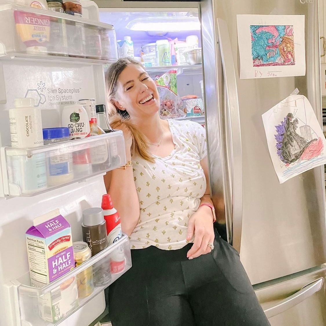 Woman cooling self in refrigerator