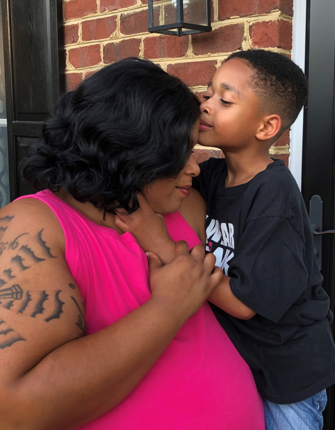 Stephanie Smith holding her son as he kisses her forehead