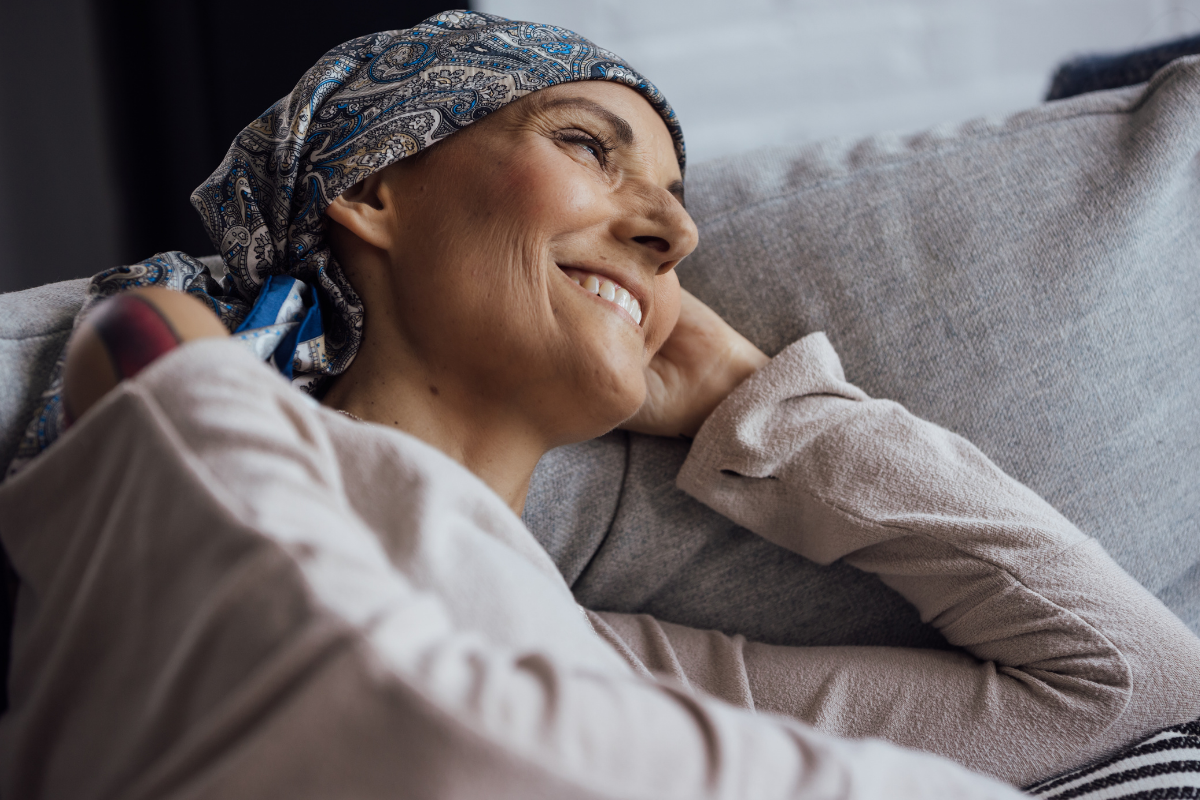 A woman smiling while laying on a couch