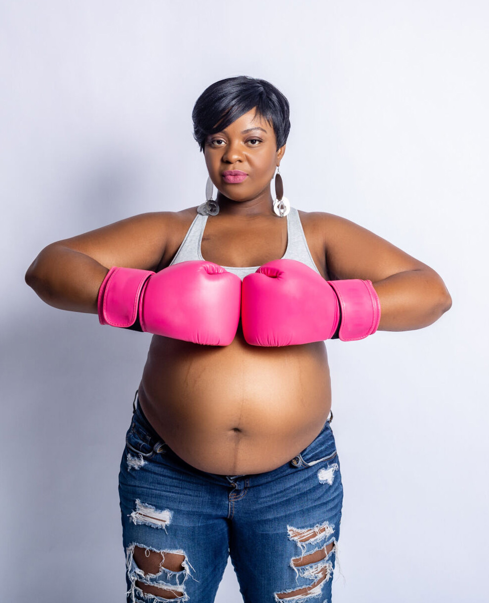 Jonise Louis poses with pink boxing gloves over her pregnant stomach