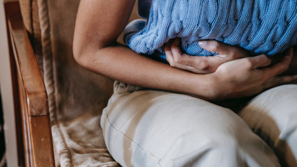 A woman bent over, holding her stomach