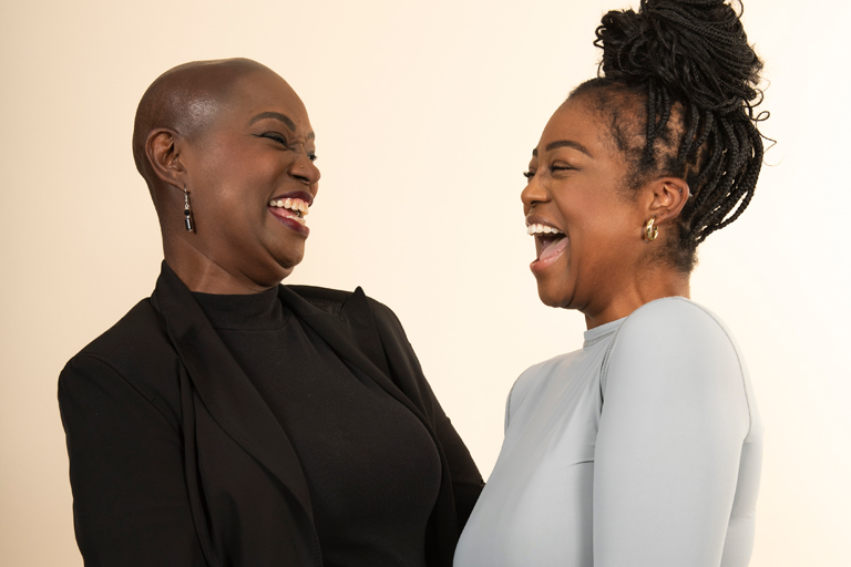 Two Black women share a joyful moment