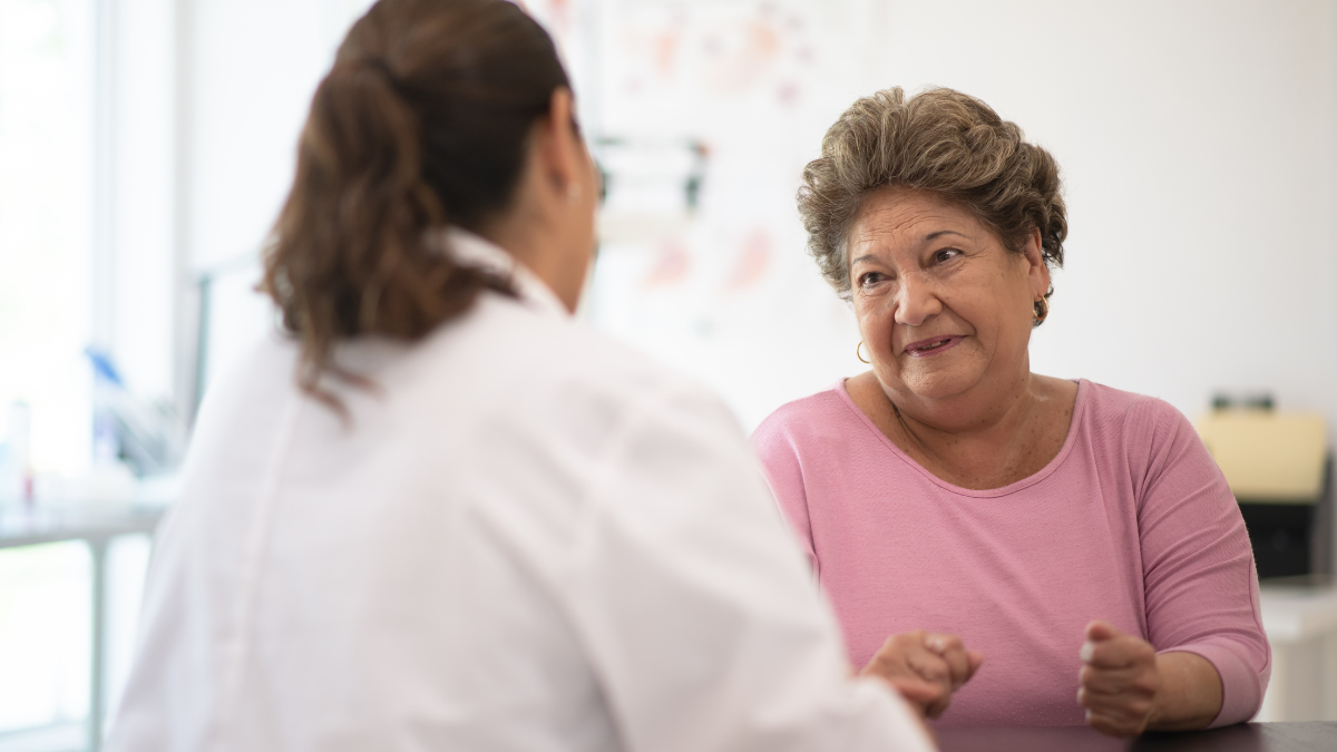 An older white woman talking to a white female doctor.