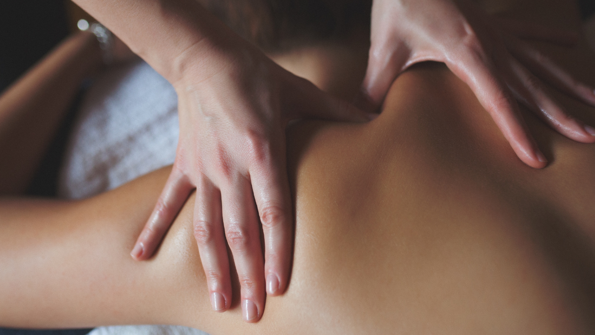 A close up of two hands giving someone a back massage