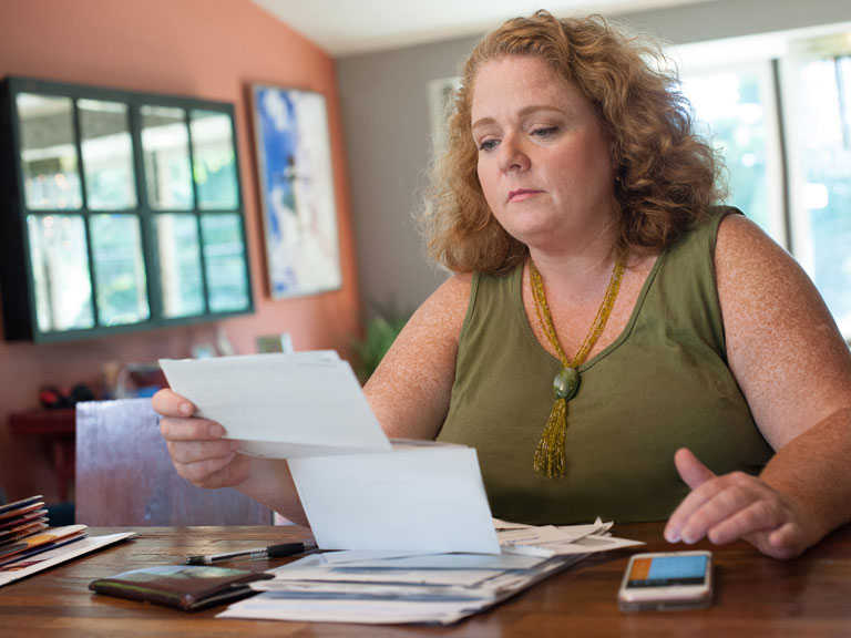 Woman at home looking at medical bills