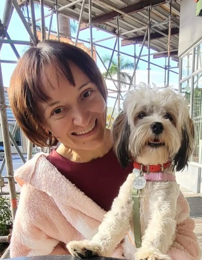 Florina Dragovic smiles widely as she holds her small dog Peanut.