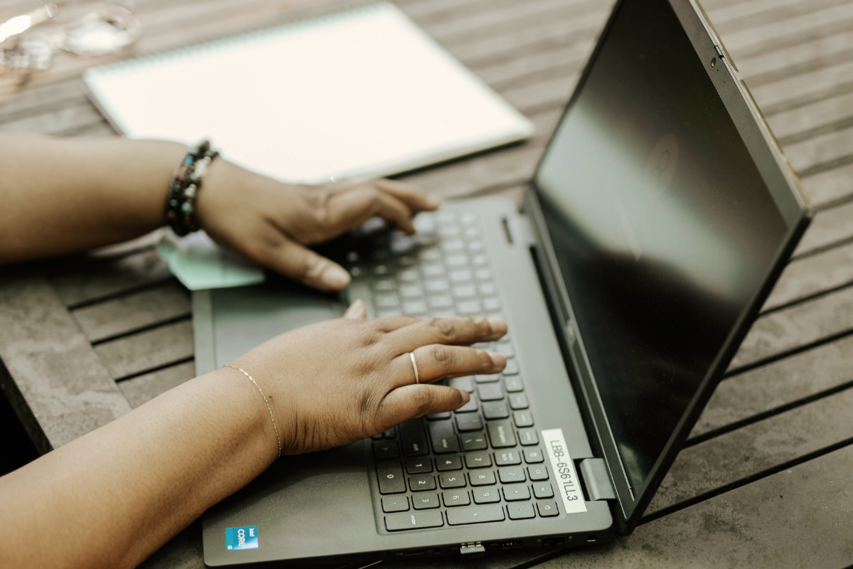 A Black woman's hands typing on a computer