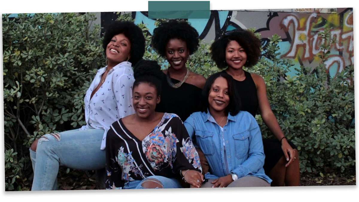 5 Black women sitting together smiling