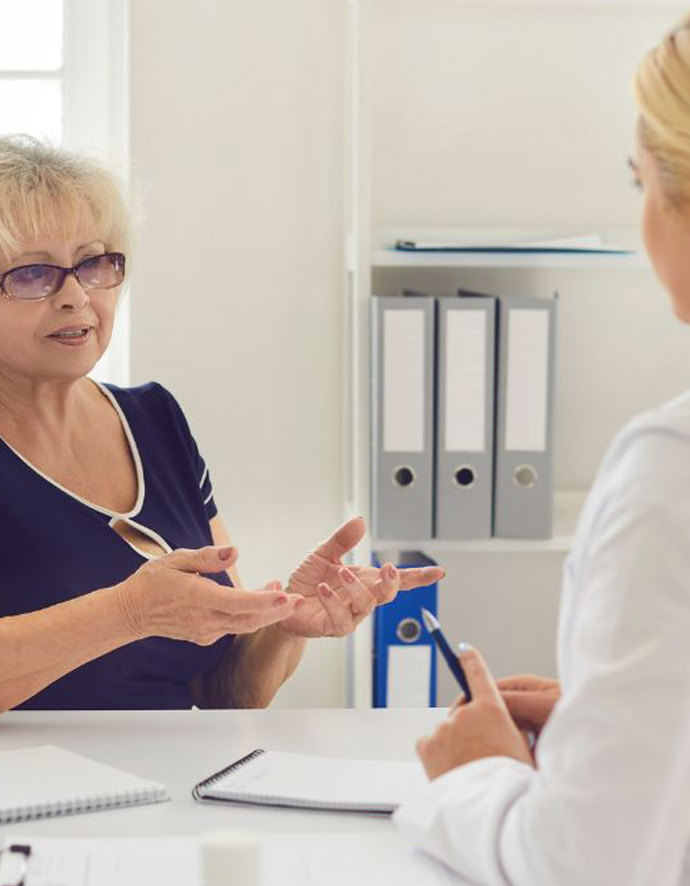A woman calmly asks her doctor questions as they meet in the doctor's office.