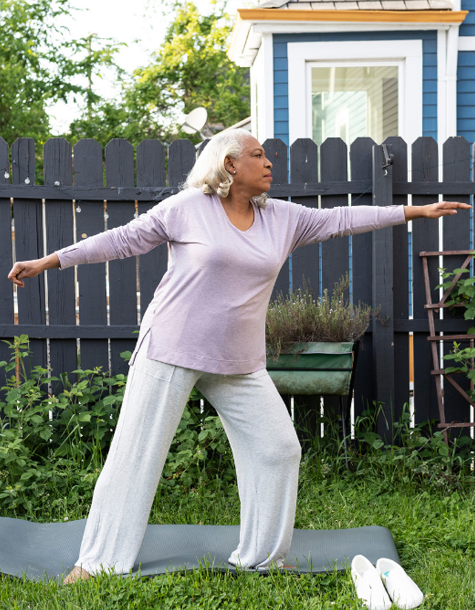 A Black woman does yoga in her backyard