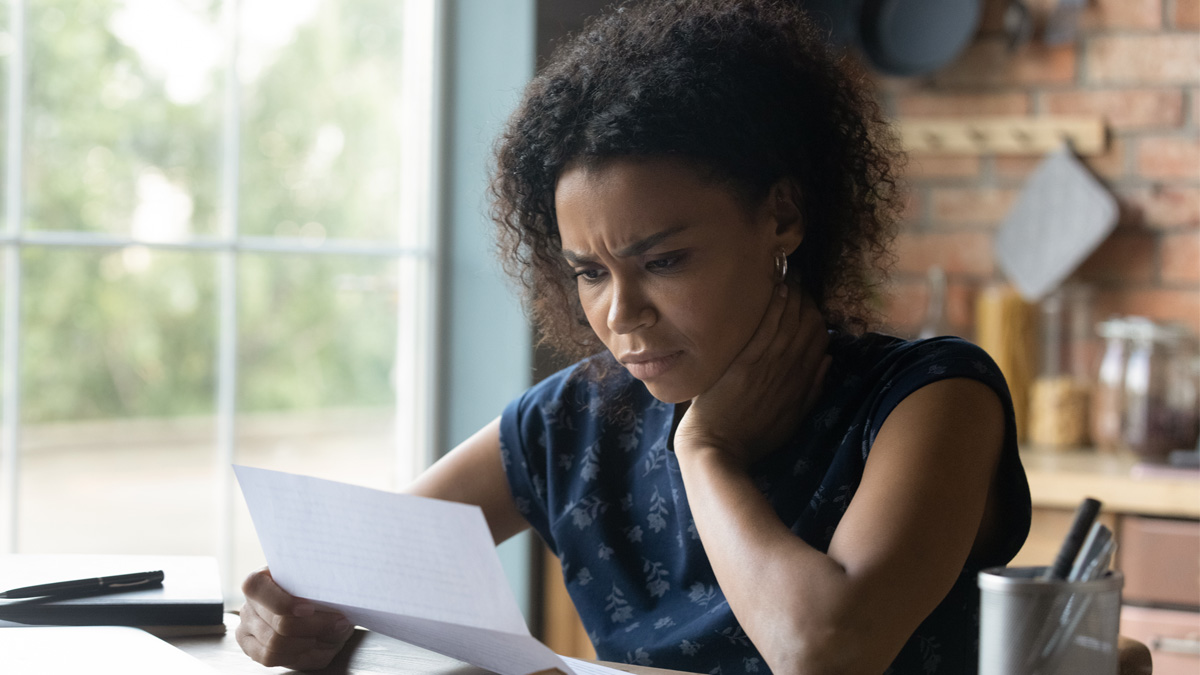 Black woman looking at inquisitively at a piece of paper.