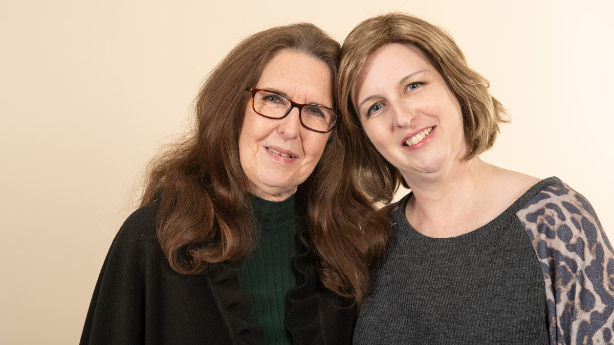 An older white woman and a young white woman in a side hug, smiling