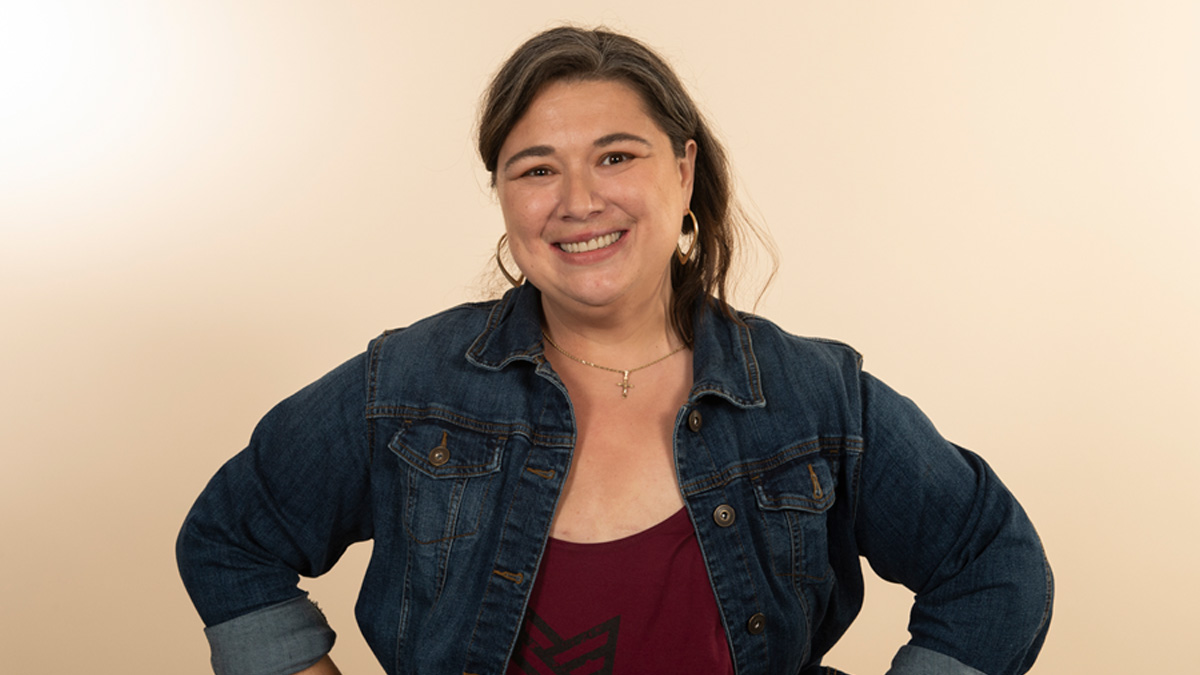 A woman smiling with her hands on her hips