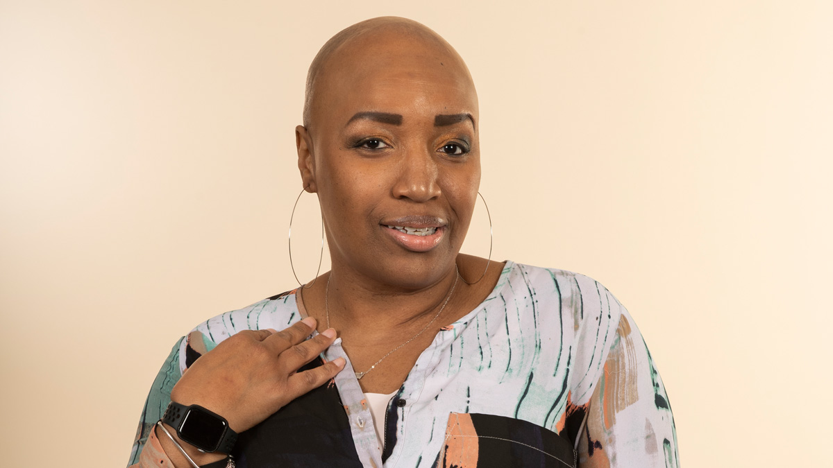 A bald Black woman smiling