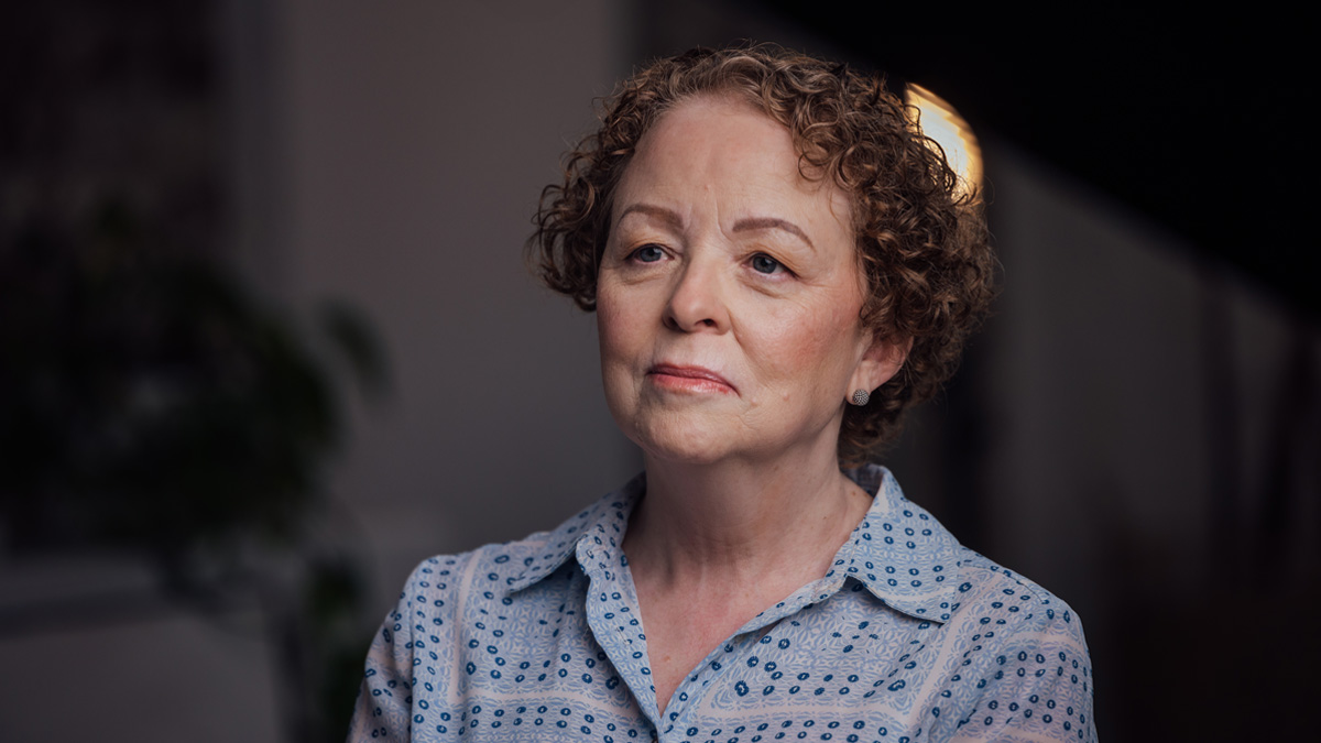 An older white woman looking off into the distance.