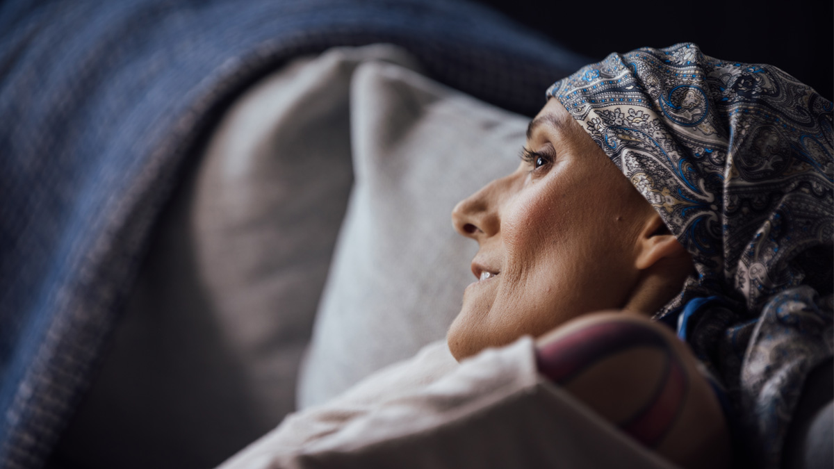 A white woman laying on her side on a couch.