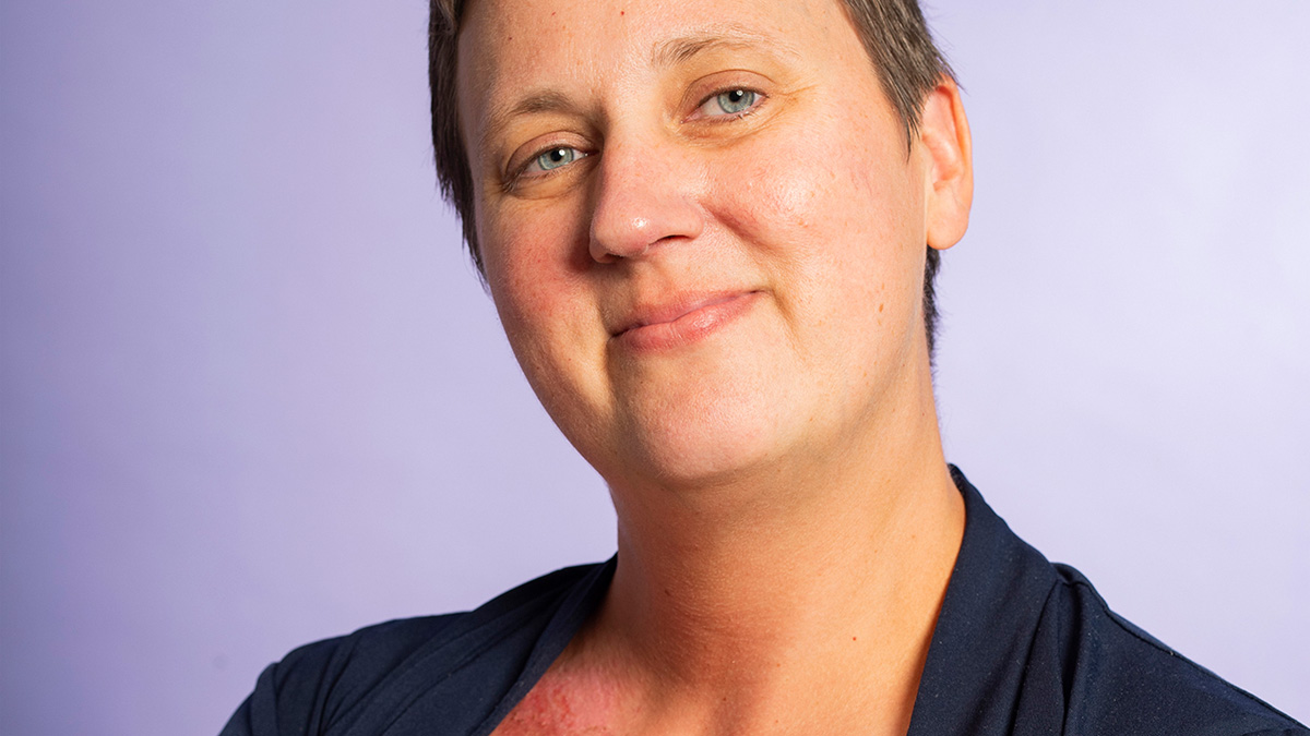 A young white woman with a pixie haircut smiling