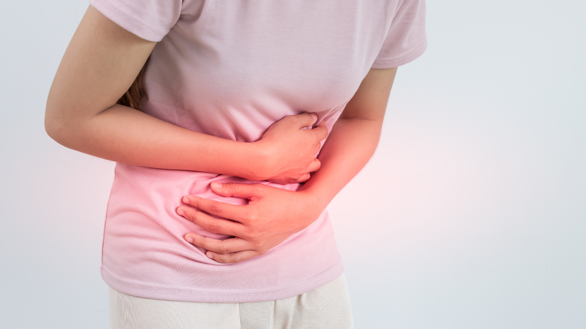 Asian woman holding her stomach in pain