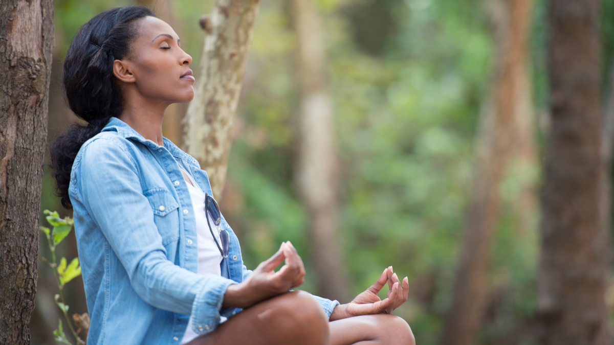 A Black woman meditating in nature
