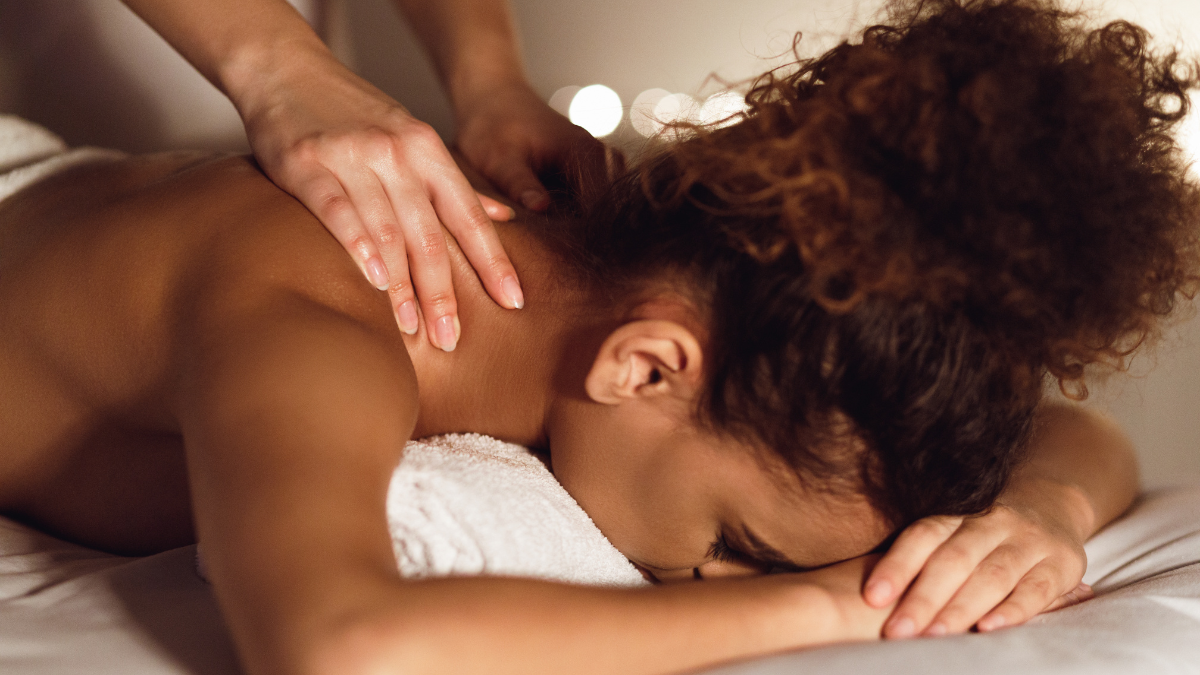 A Black woman receiving a back massage