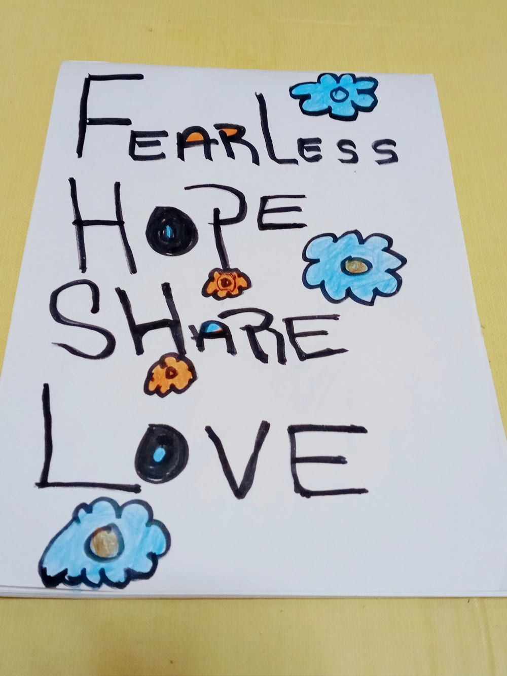 Hand-drawn sign with the words Fearless, Hope, Share, and Love surrounded by flowers