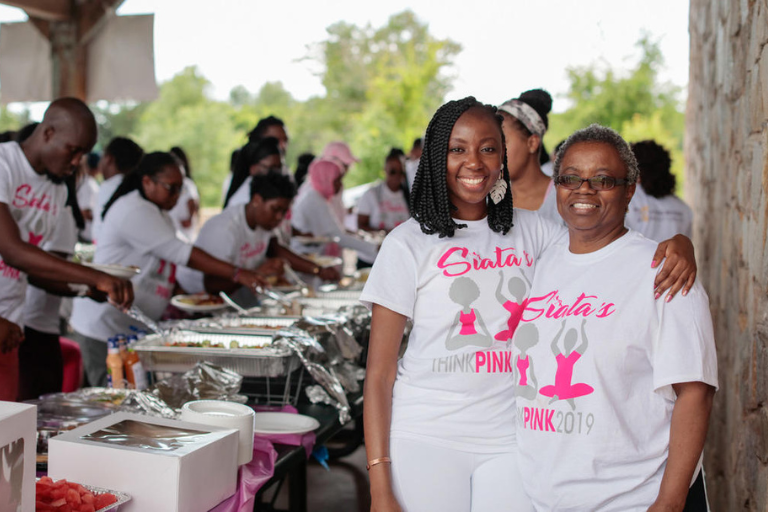 Mom and daughter at fundraiser, people at buffet line in distance