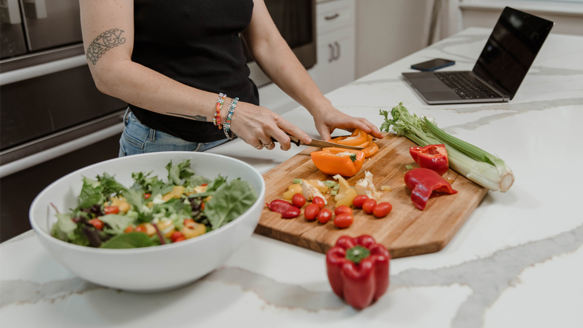 A woman chopping up peppers on a cutting board