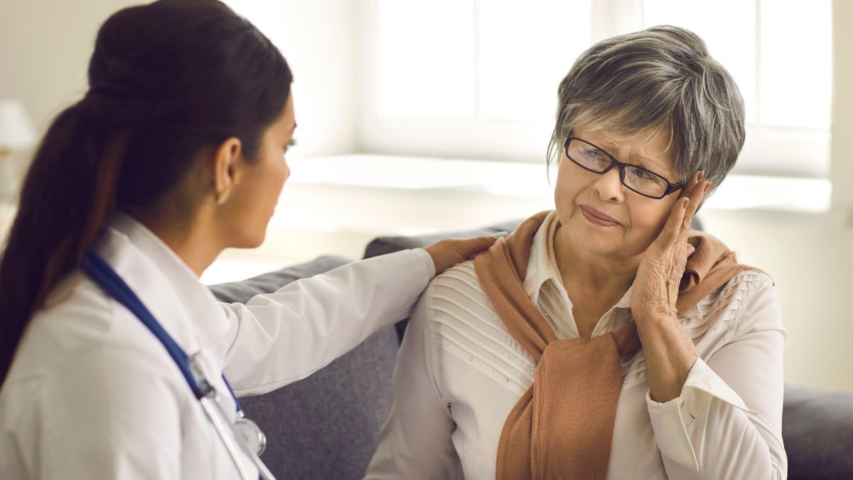 Doctor putting her hand on the shoulder of a distraught elderly woman.
