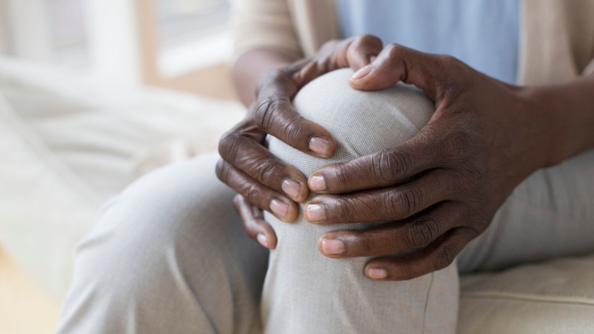 Closeup of two Black hands holding a knee