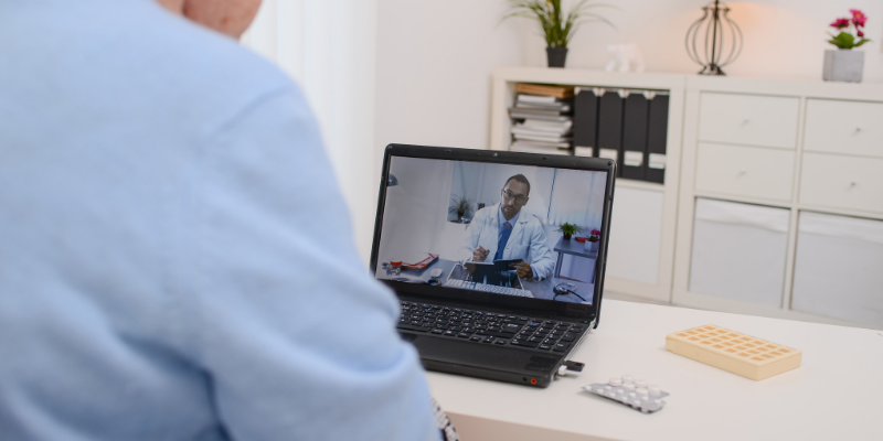 A patient talks to a doctor on a video call on a laptop