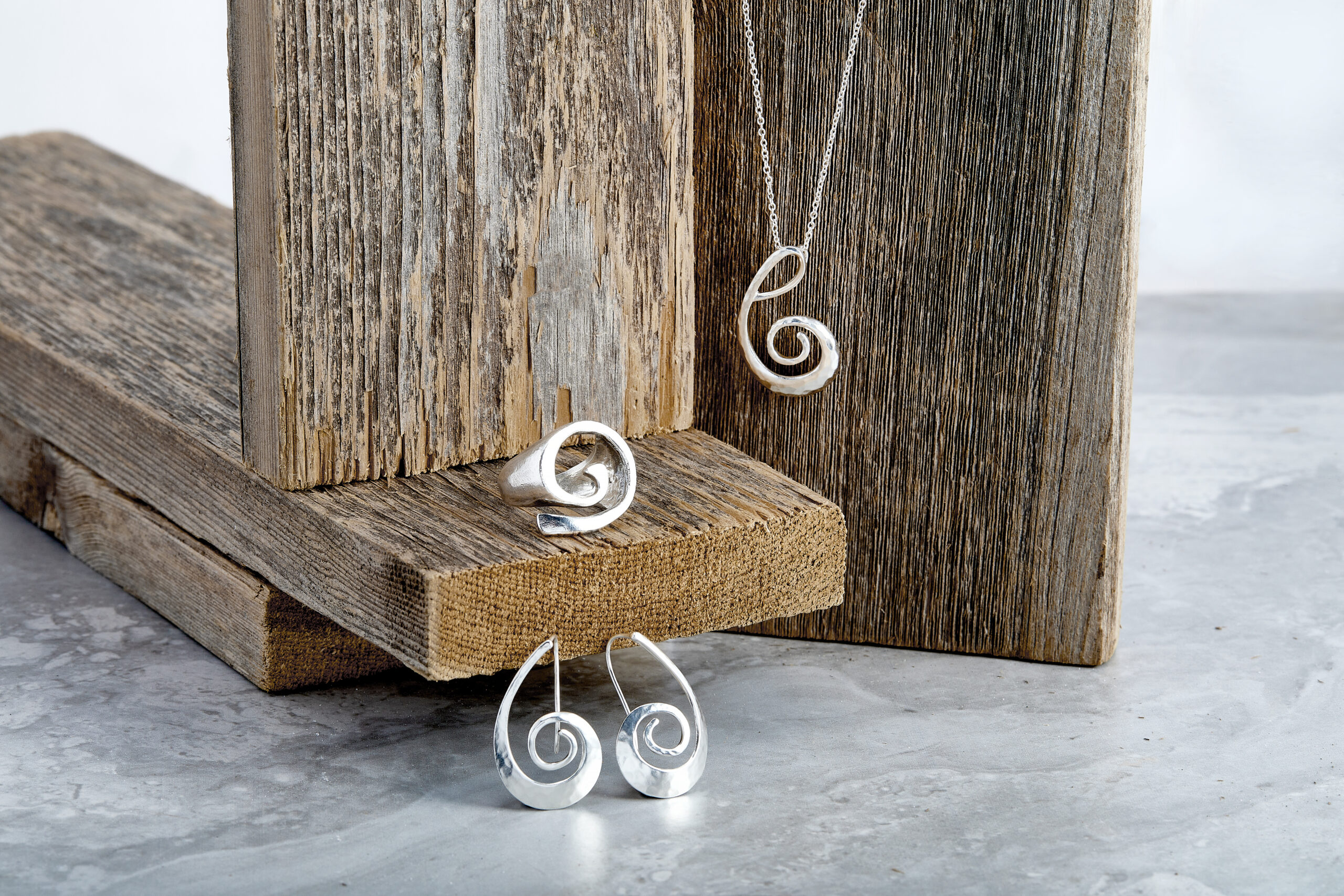 Silver and spiral shaped earrings, ring, and necklace