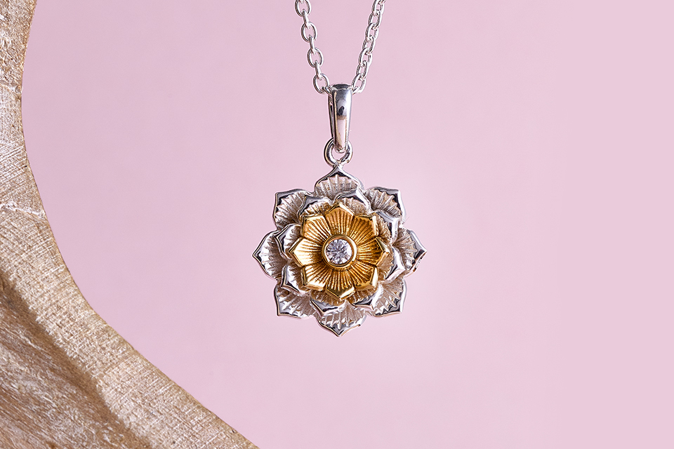 A close-up of a silver and gold flower necklace