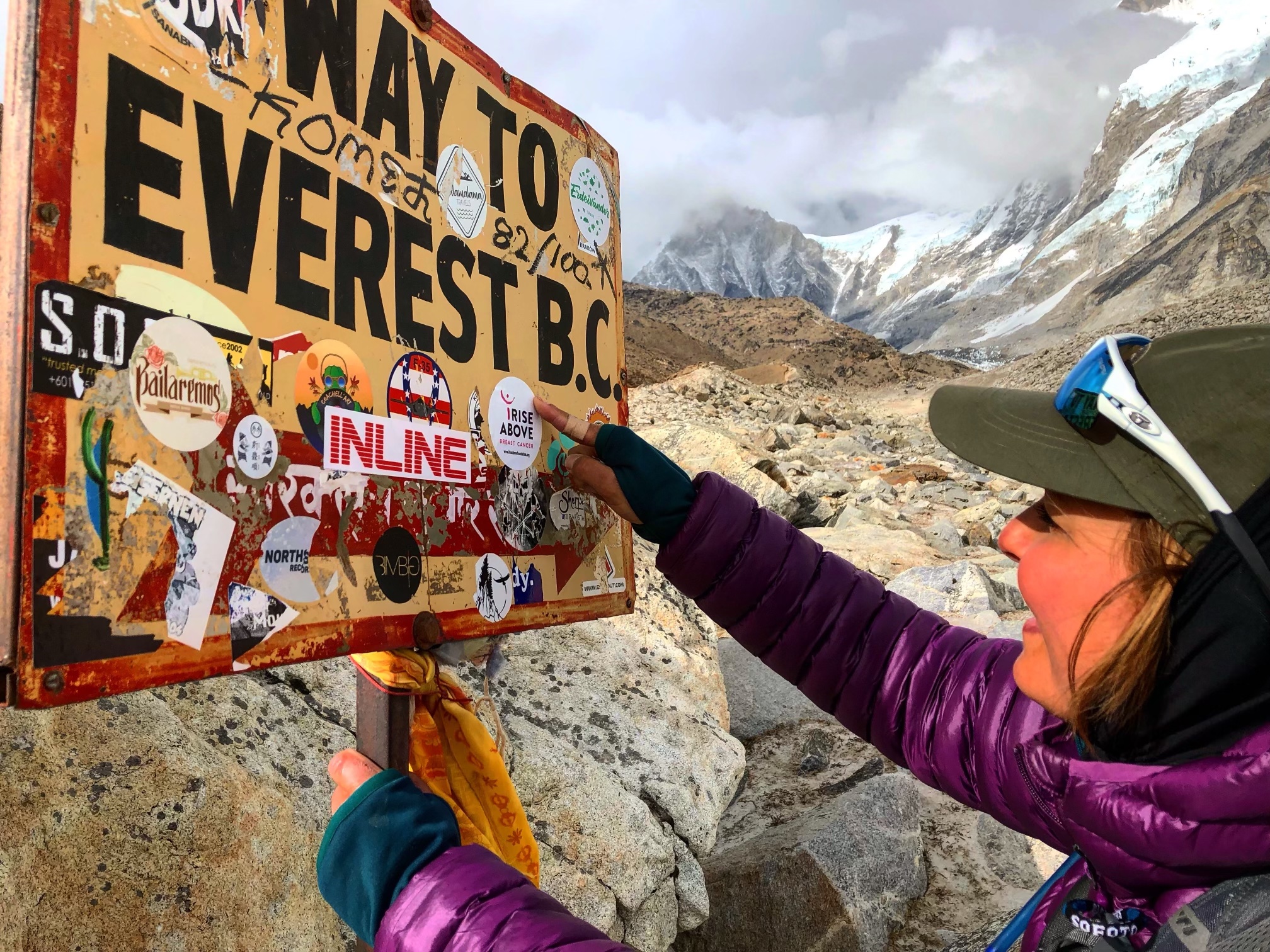 Gillian pointing to a sign that says "Way to Everest B.C."