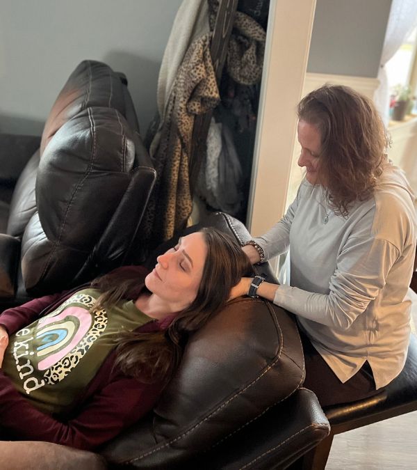 Amanda receives cranial sacral massage from therapist behind her head