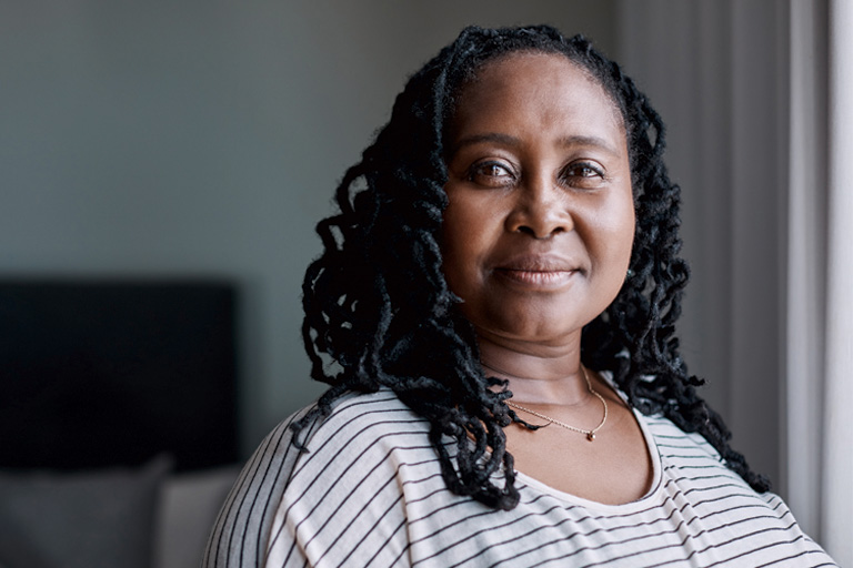 An older Black woman looks serenely at the viewer