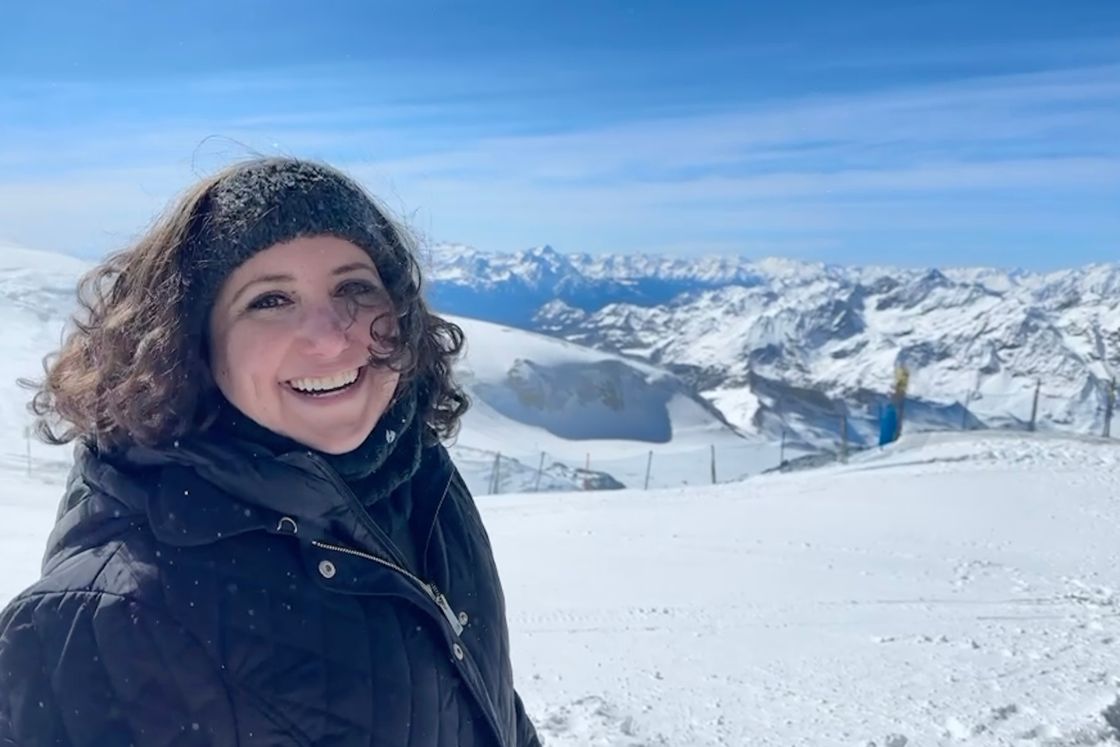 Lisa Francis smiles on top of a snowy mountain in Switzerland