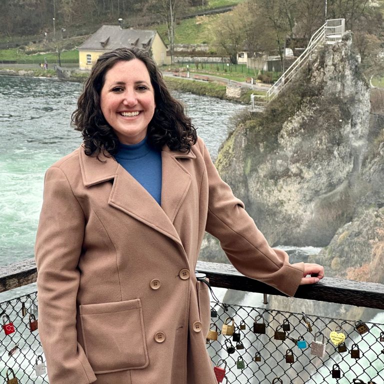 Lisa Francis stands in front of a scenic Swiss lake