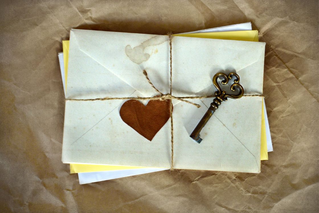 Envelope with heart and key tied with string.