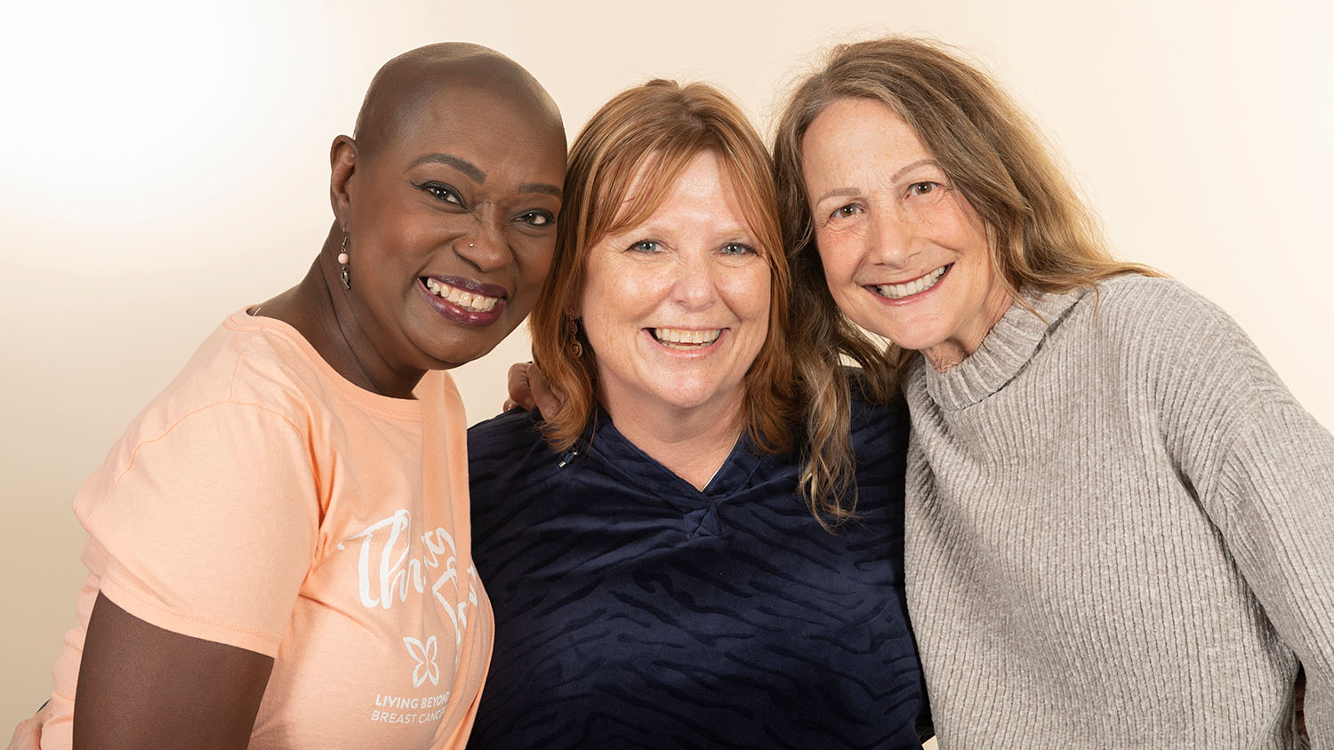 Group of three women, one Black, two white, smiling