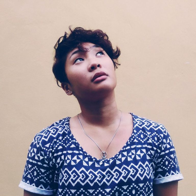 A young woman looks up curiously at the sky