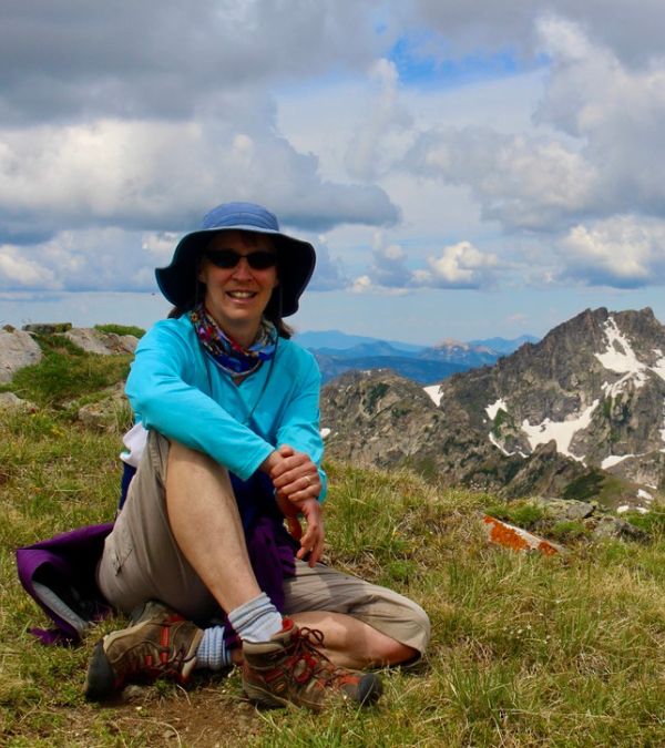 Mary Evelyn Burman rests on a mountain top.