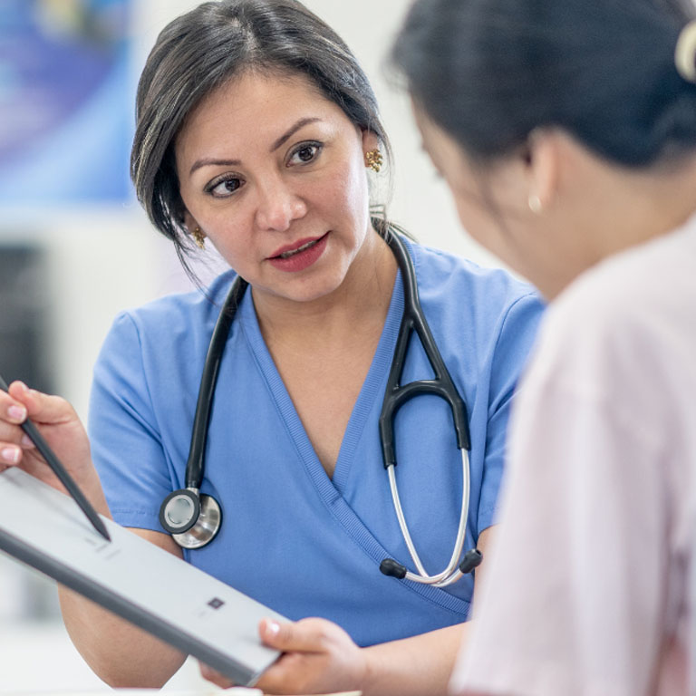 A female Asian doctor in conversation with a female Asian patient