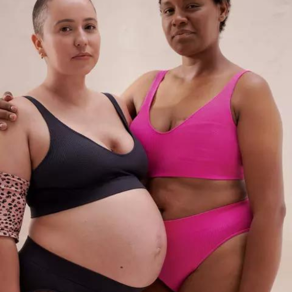 two women wearing a black and pink matching underwear set