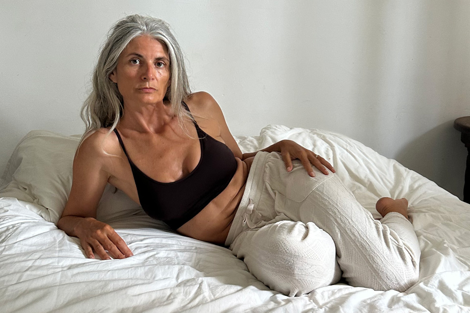 A woman posing on a bed.
