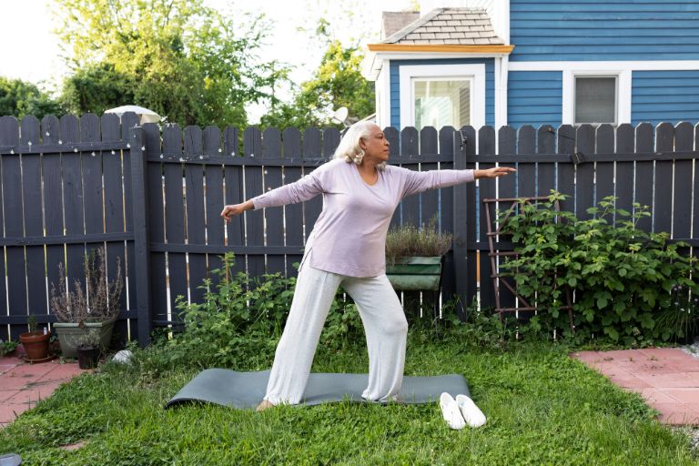 A Black woman does yoga in her backyard