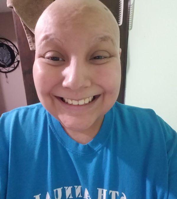 Ashlynn Gomez without hair or headcovering but with a big smile