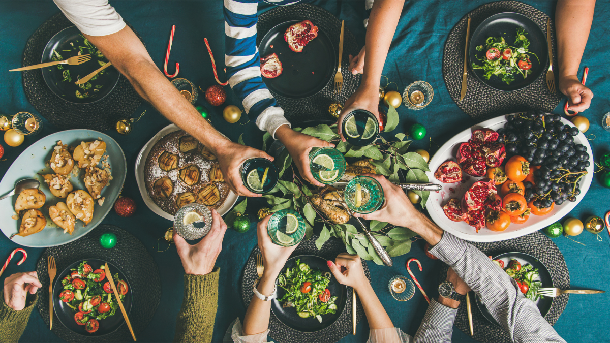 Holiday table with food and hand overstretched toasting the meal