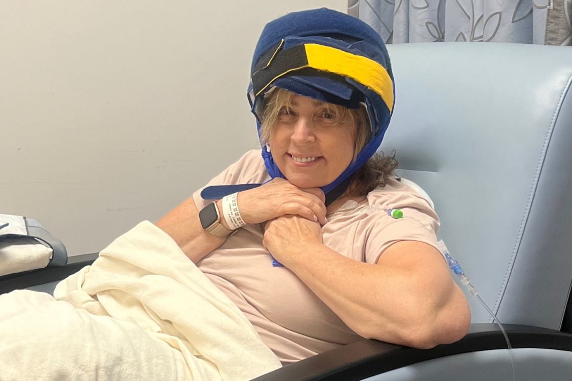 Carolyn Nickels in her chemo suite chair with a cold cap