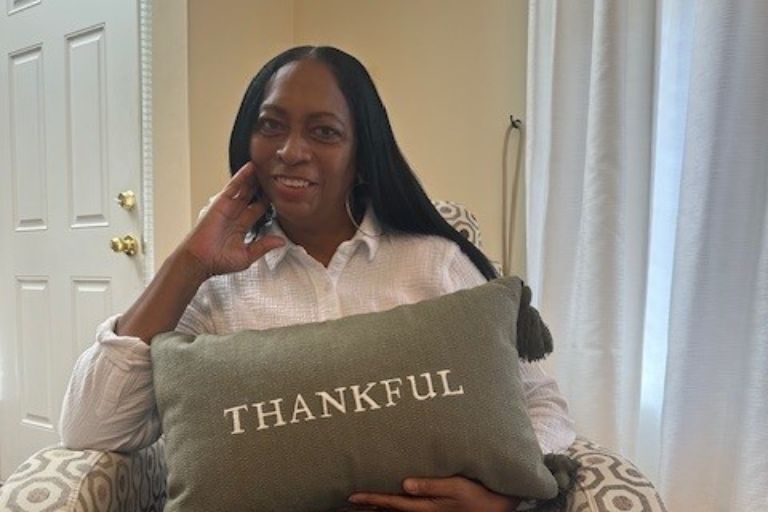 Kimberley Robinson holds a "thankful" pillow