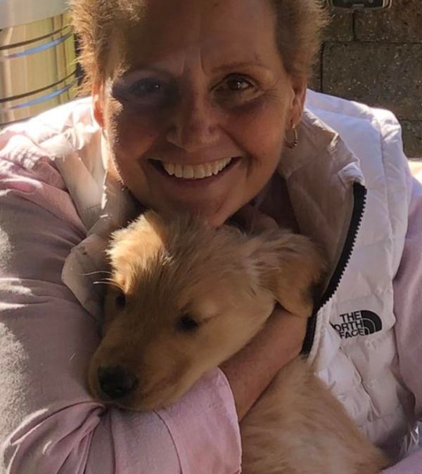 Jacqueline Beck hugs a golden puppy